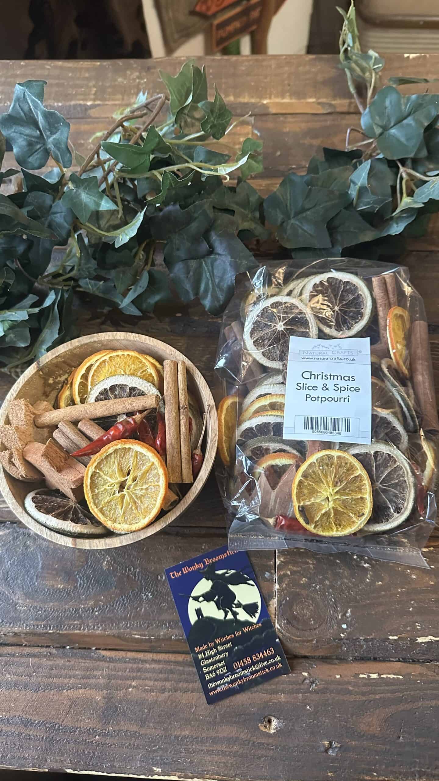 Dried citrus slices and spices for Christmas potpourri on rustic wooden table.